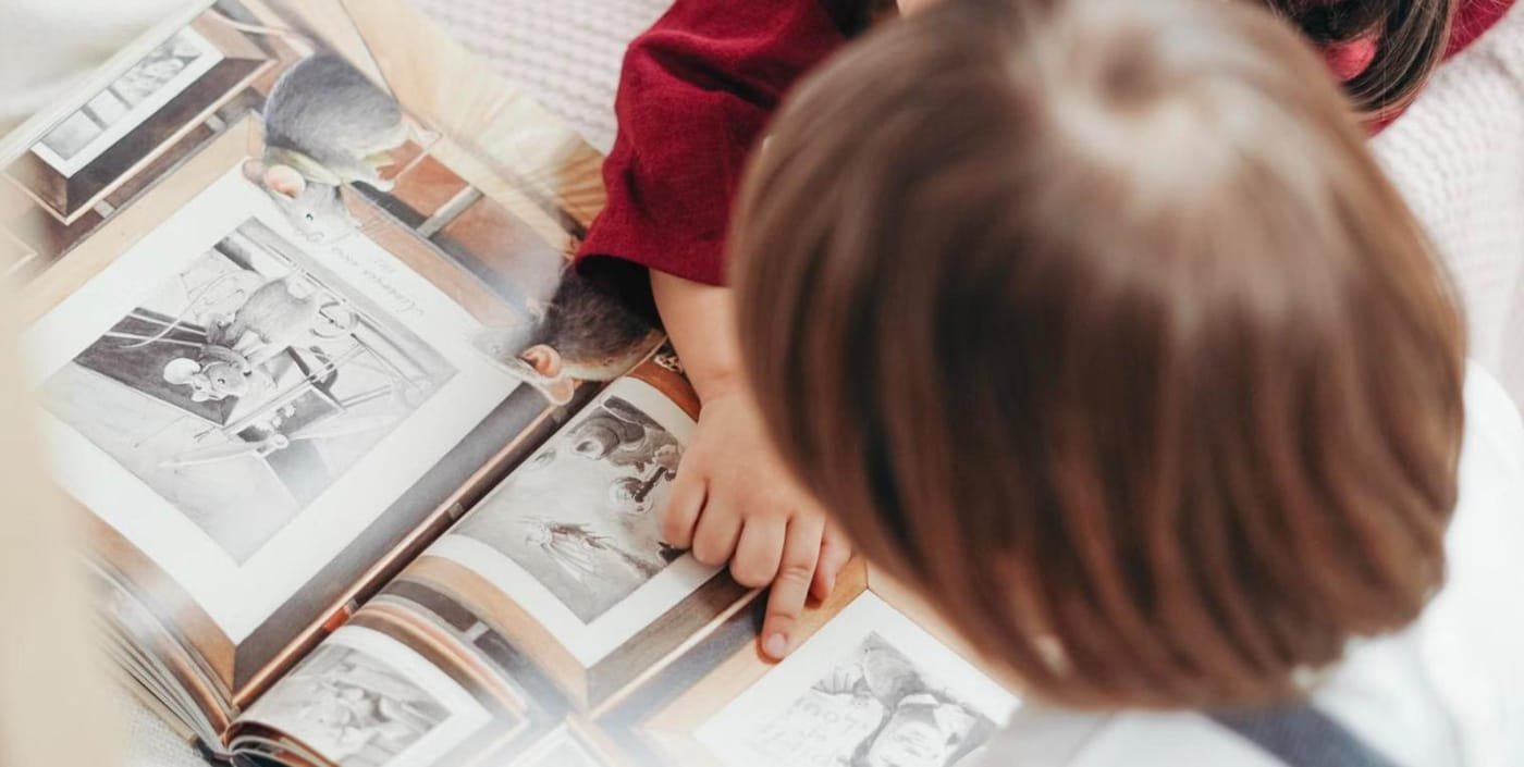 Two children looking at an illustrated picture book together